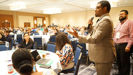 A man talking to a crowded conference room of attendees